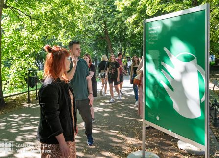 fotografia. wystawa Wyszehrad to ludzie na krakowskich plantach. ludzie oglądają plakaty ustawione w rzędzie.